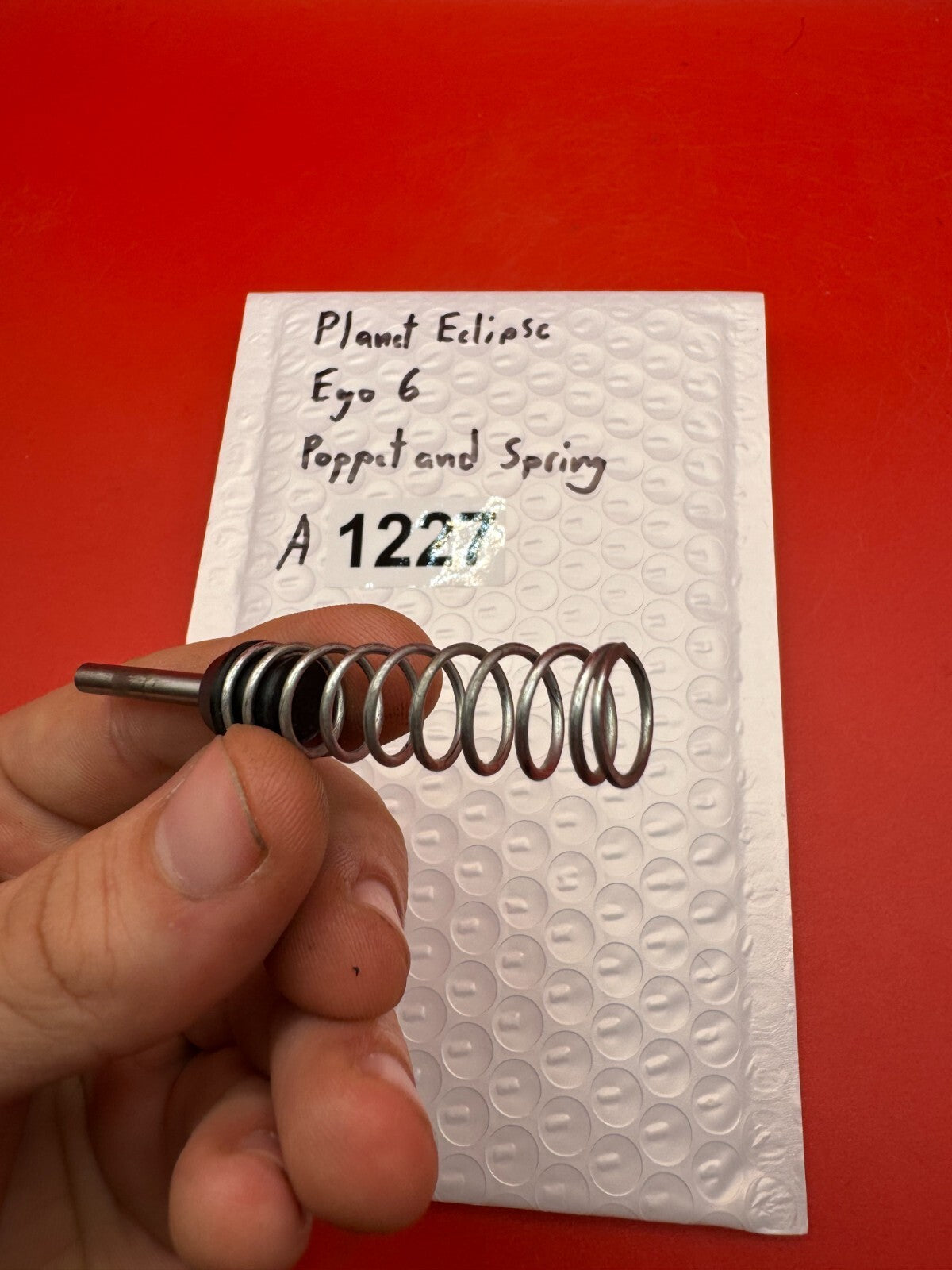 Planet Eclipse Ego 6 Poppet and Spring - used paintball poppet valve and spring - black/silver